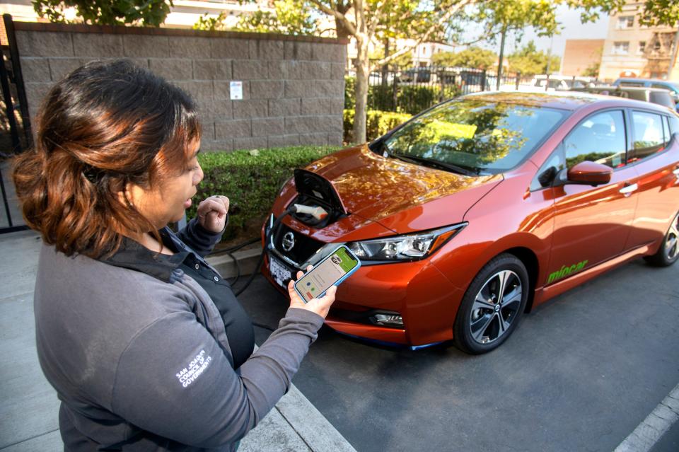 Stockton Mobility Collective car share project manger Christine Corrales uses an app to access a Miocar Nissan Leaf at the San Joaquin Council of Governments office in downtown Stockton.