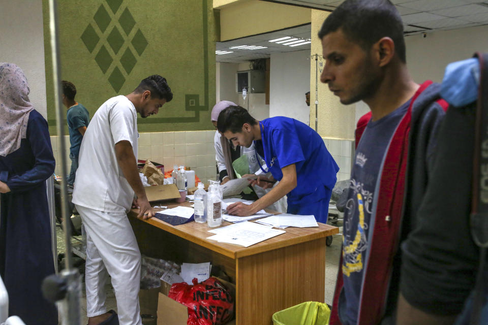 El personal médico se coloca alrededor de una mesa mientras trabaja en el Hospital al-Aqsa en Deir al Balah, en el centro de la Franja de Gaza, el lunes 6 de noviembre de 2023. (Samar Abu Elouf/The New York Times)