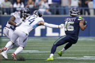 Seattle Seahawks wide receiver Tyler Lockett (16) breaks from the grasp of Tennessee Titans cornerback Elijah Molden (24) as he runs for a touchdown after a reception during the first half of an NFL football game, Sunday, Sept. 19, 2021, in Seattle. (AP Photo/Elaine Thompson)