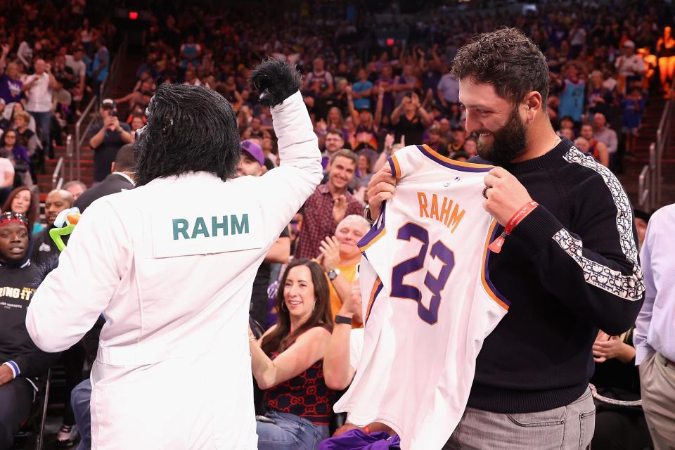 Professional golfer Jon Rahm is presented a Phoenix Suns jersey by "The Gorilla" during the first half of Friday's Game 3 of the NBA Western Conference semifinals at Footprint Center.