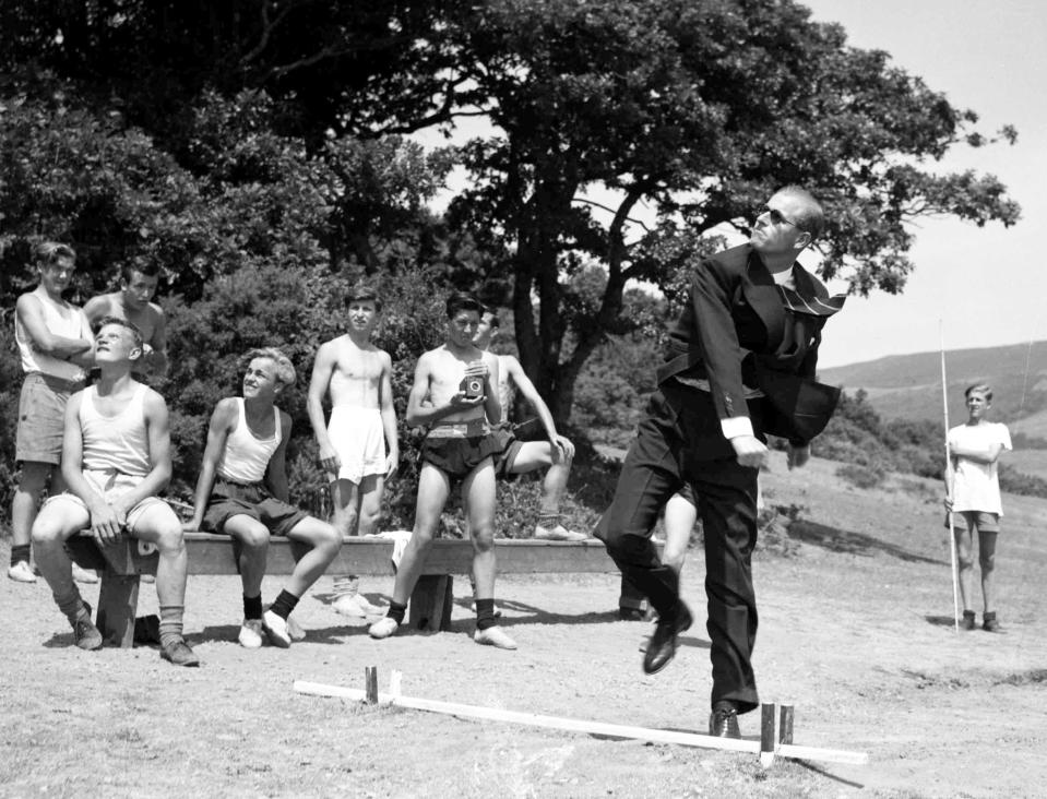 FILE - In this July 12, 1949 file photo, the Duke of Edinburgh throws a javelin during a visit to the Outward Bound Sea School, in Wales, watched by some of the boys. Buckingham Palace officials say Prince Philip, the husband of Queen Elizabeth II, has died, it was announced on Friday, April 9, 2021. He was 99. Philip spent a month in hospital earlier this year before being released on March 16 to return to Windsor Castle. Philip, also known as the Duke of Edinburgh, married Elizabeth in 1947 and was the longest-serving consort in British history. (AP Photo/Leslie Priest, File)