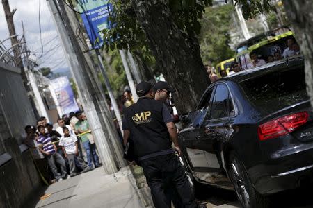 Forensic technicians inspect the car where Guatemalan lawyer Francisco Palomo was shot dead in Guatemala City, June 3, 2015. REUTERS/Jorge Dan Lopez