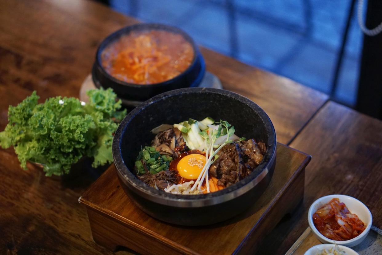 Dolsot bibimbap - Korean mixed rice, Include steamed rice, vegetables, pork and fried egg on top, served in a hot stone pot, Dolsot means stone pot in Korean.