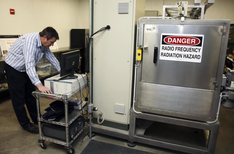 In this Dec. 6, 2012, photo, Andreas Neuber, an electrical engineering professor at Texas Tech University, monitors a high powered microwave at Microzap, Inc., in Lubbock, Texas. Chief executive officer Don Stull says the company's technology allows bread to stay mold-free for 60 days. The bread is bombarded with microwaves for about 10 seconds, which kills the mold spores, he said. (AP Photo/John Mone)