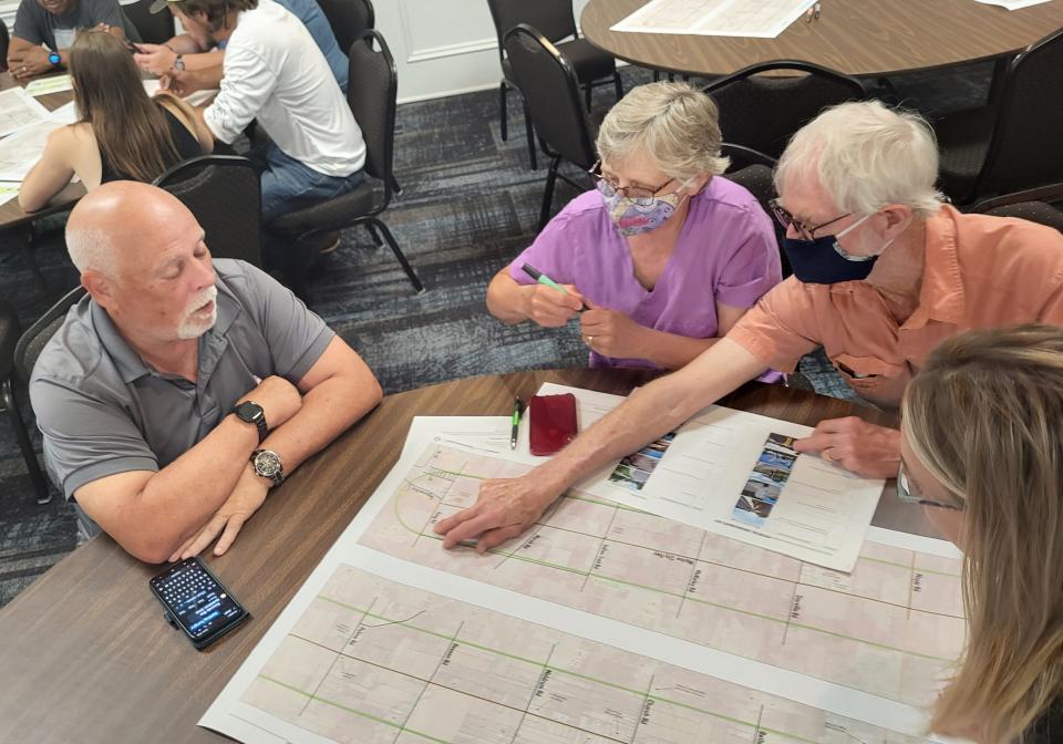 Cotrellville residents Nancy and Chet Kilanowski, right, look over a map of the 11-mile Marine City Highway corridor on Wednesday, June 29, 2022, at the Harvest Event Center in Marine City, while Chris McCue and Stacy Bellis watch on.