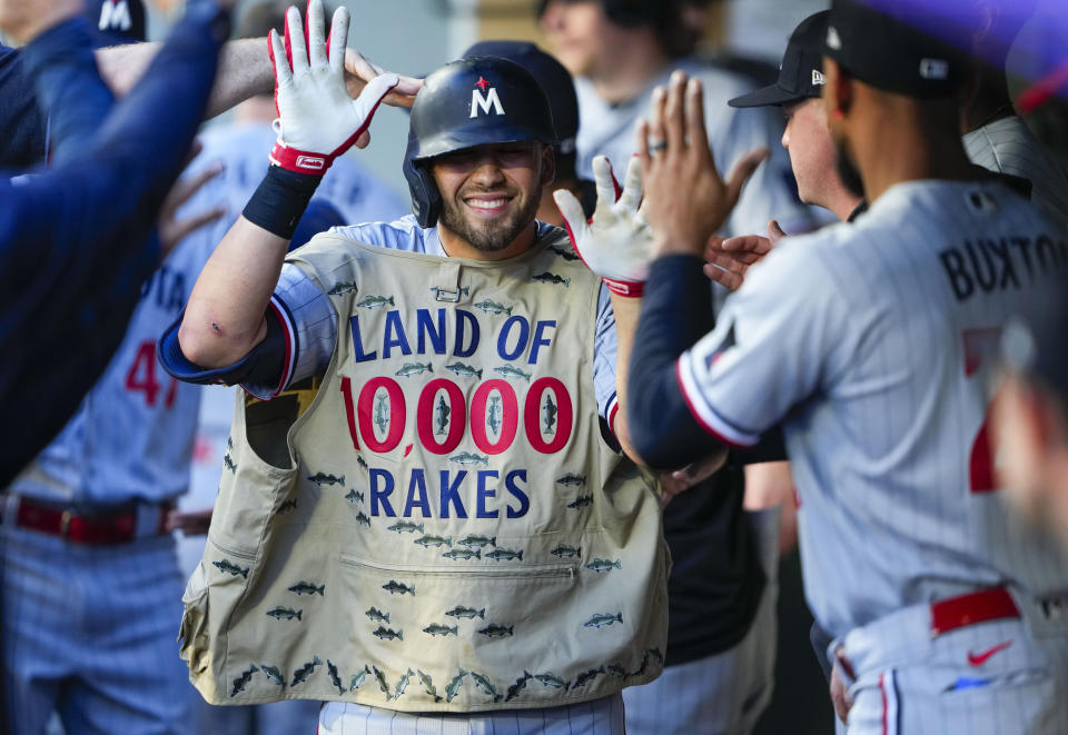 Minnesota Twins' Alex Kirilloff wears a fishing vest in the dugout to celebrate his two-run home run against the Seattle Mariners during the third inning of a baseball game, Tuesday, July 18, 2023, in Seattle. (AP Photo/Lindsey Wasson)