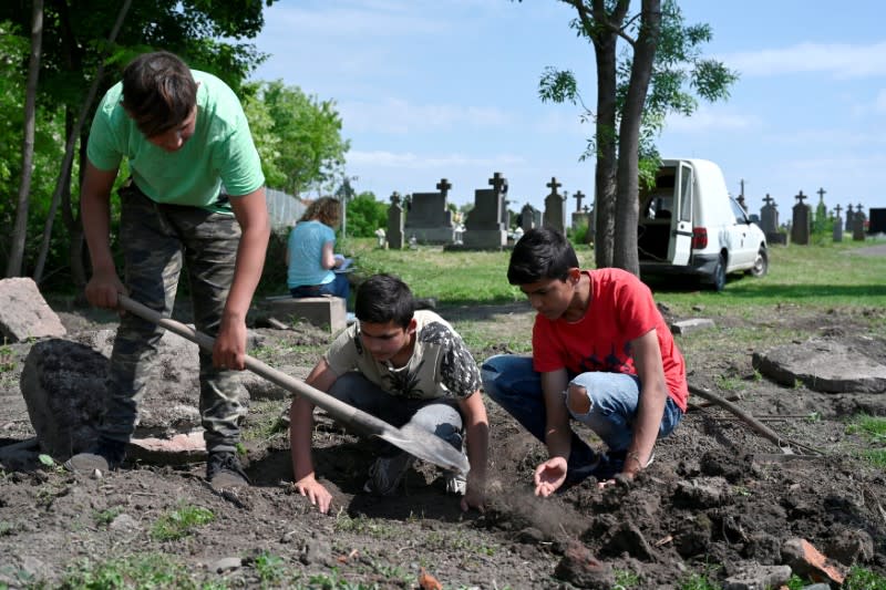 Jóvenes de una comunidad romaní trabajan en la recuperación de un antiguo cementerio judío descubierto en Vinodol, Eslovaquia. Junio 5, 2021. REUTERS/Radovan Stoklasa