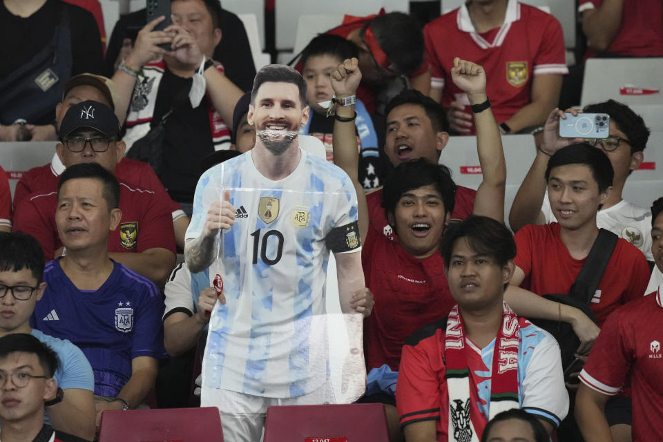 Fans display a cutout of soccer superstar Lionel Messi during a friendly soccer match between Argentina and Indonesia at Gelora Bung Karno Main Stadium in Jakarta, Indonesia, Monday, June 19, 2023. (AP Photo/Achmad Ibrahim)