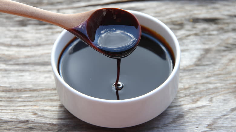 Molasses dripping from spoon into bowl