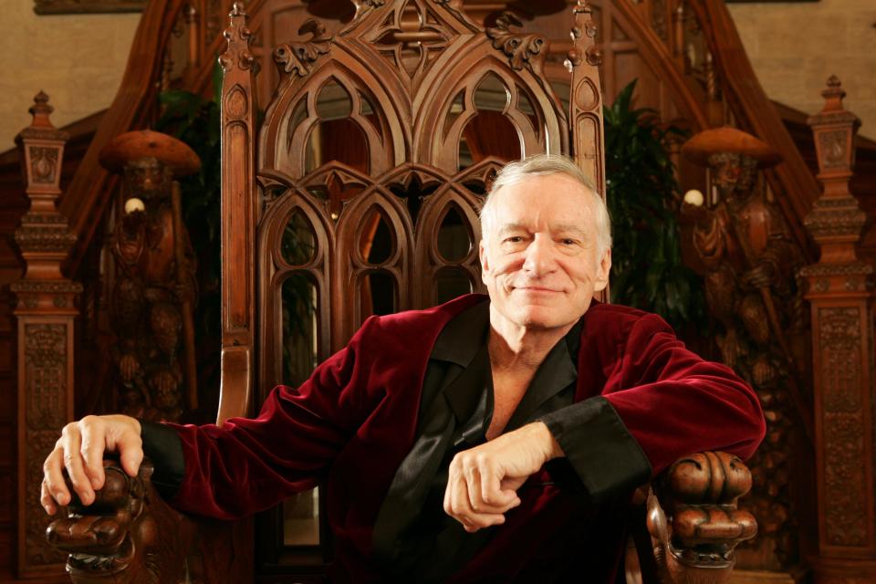 Hugh Hefner sits in a chair and poses for a photo in 2005.