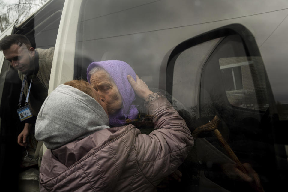 FILE - Olha Faichuk, 79, kisses her neighbor as she is evacuated from her home, which was heavily damaged by a Russian airstrike in Lukiantsi, Kharkiv region, Ukraine, on Tuesday, April 16, 2024. (AP Photo/Evgeniy Maloletka, File)