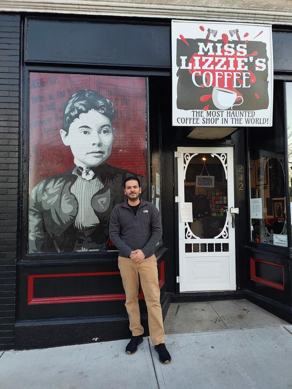 William Silvia stands in front of the window mural he designed, depicting Lizzie Borden, in the front window of Miss Lizzie's Coffee at 242 Second St. in Fall River.
