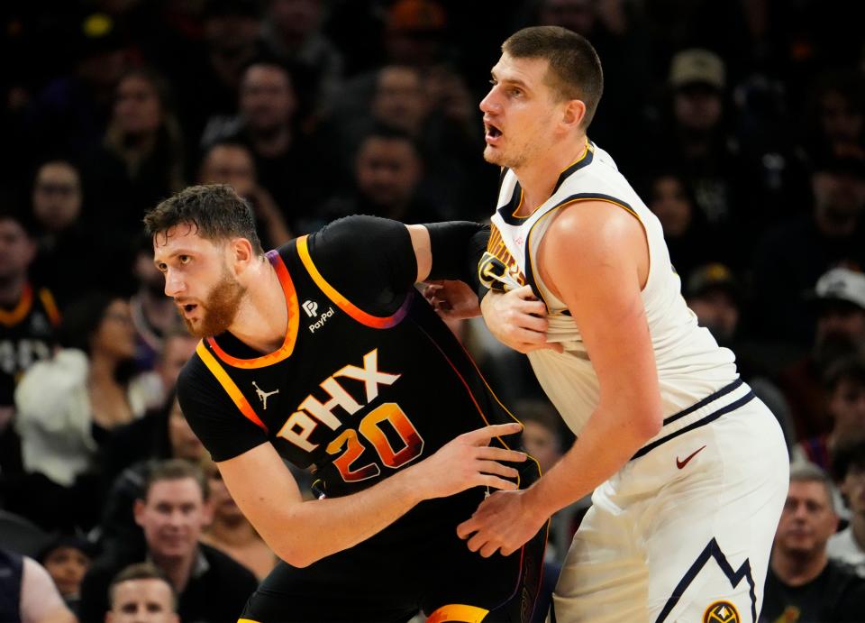 Phoenix Suns center Jusuf Nurkic (20) collides with Denver Nuggets center Nikola Jokic (15) in the second half at Footprint Center in Phoenix on Dec. 1, 2023.