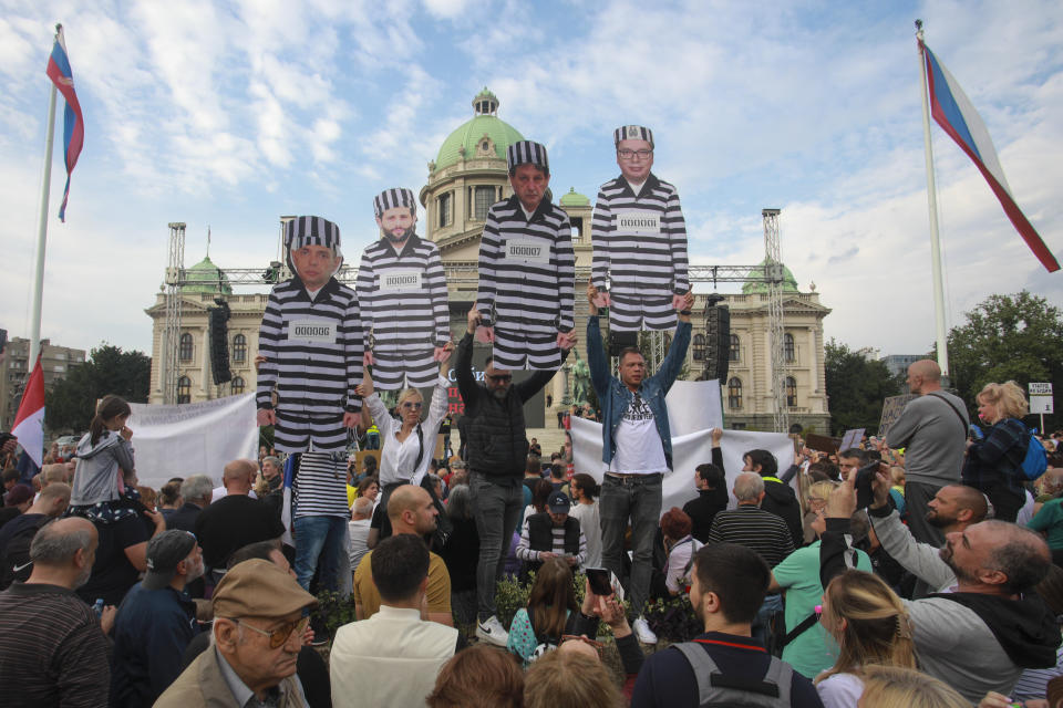 People hold posters depicting Serbian President Aleksandar Vucic, right, Interior Minister Bratislav Gasic, second right, mayor of Belgrade Aleksandar Sapic, second left, and director of the Security Intelligence Agency Aleksandar Vulin wearing prison uniforms during a protest, in Belgrade, Serbia, Saturday, June 17, 2023. Tens of thousands of anti government protesters have staged marches in Belgrade and other Serbian towns against Serbian President Aleksandar Vucic, pledging to “radicalize” weeks of peaceful gatherings that have shaken his autocratic rule. The demonstrators in Belgrade blocked the main highway that leads through the capital and chanted slogans for Vucic to resign, something that he has repeatedly rejected. (AP Photo/Milos Miskov)