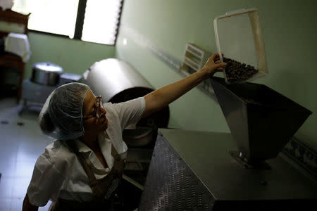 Nancy Silva processes cocoa beans at the Kirikire chocolate factory in Caracas, Venezuela October 4, 2017. REUTERS/Carlos Garcia Rawlins