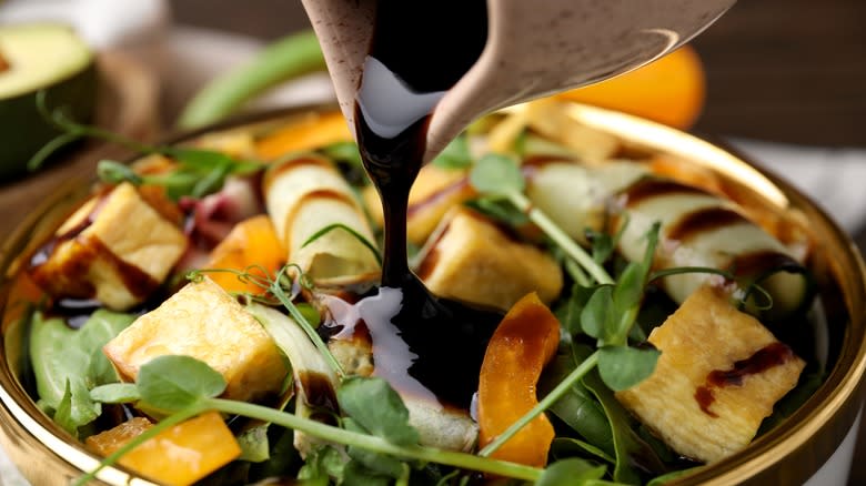 pouring dressing on salad