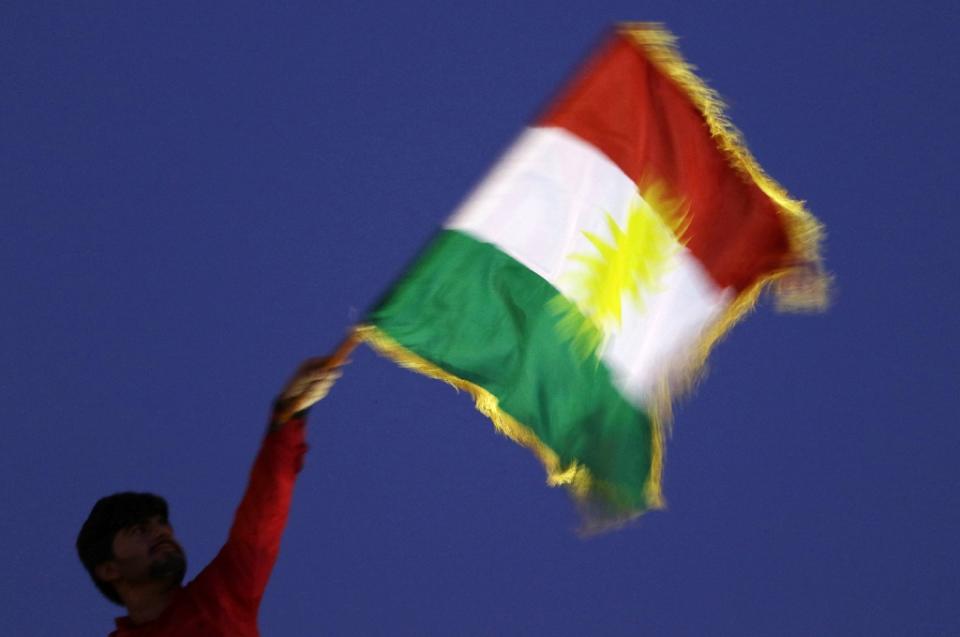 <p>A man waves a Kurdish flag during an event to urge people to vote in the upcoming independence referendum in Arbil, the capital of the autonomous Kurdish region of northern Iraq. (Photo: Safin Hamed/AFP/Getty Images) </p>