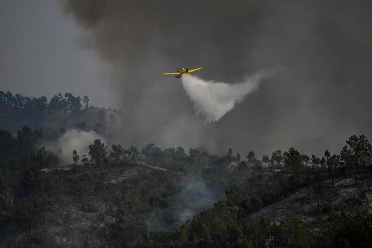 A firefighter plane drops water over a wildfire in Odeceixe, south of Portugal (AFP via Getty Images)