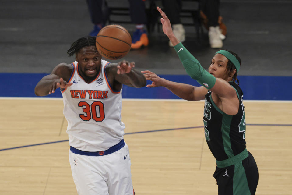 New York Knicks forward Julius Randle (30) passes the ball against Boston Celtics guard Romeo Langford (45) during the second half of an NBA basketball game in New York, Sunday, May 16, 2021. (Vincent Carchietta/Pool Photo via AP)