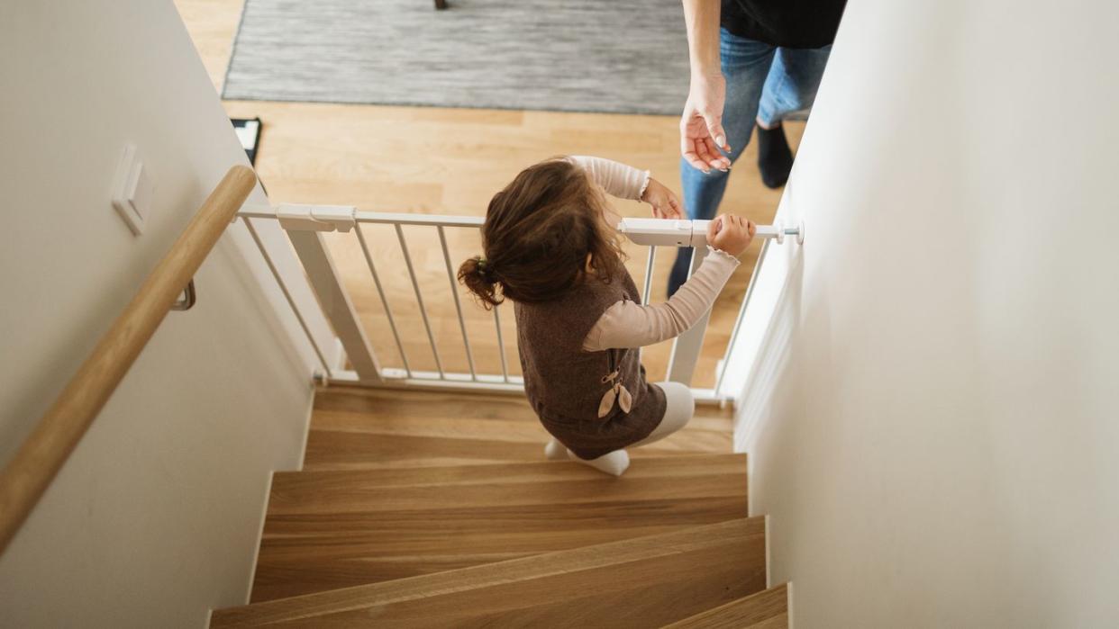 girl opening baby gate in staircase
