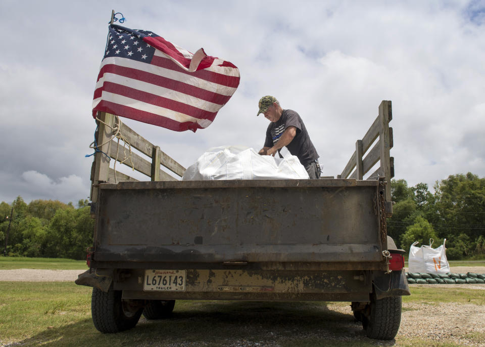 John Matherne, 62, hauled giant bags of sand to areas around Lafitte, La., as residents prepare for the arrival of two tropical storms along the south Louisiana coast on Monday, Aug. 24, 2020 . (Chris Granger/The Times-Picayune/The New Orleans Advocate via AP)