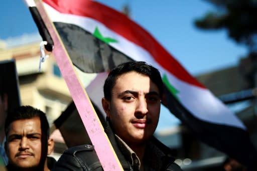 Syria Kurds wave the national flag during a demonstration in the northeastern city of Qamishli on December 23, 2018, seeking the Syrian army's protection against a threatened assault by Turkey