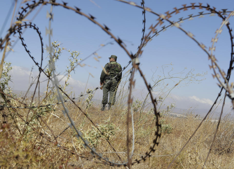 Syrian army soldier stands guard near village of Tal Kroum, Syria, Tuesday, Aug. 14, 2018. The Russian military said Tuesday that its forces in Syria will help U.N. peacekeepers fully restore patrols along the frontier with the Israeli-occupied Golan Heights, reflecting Moscow's deepening role in mediating between the decades-old foes. (AP Photo/Sergei Grits)