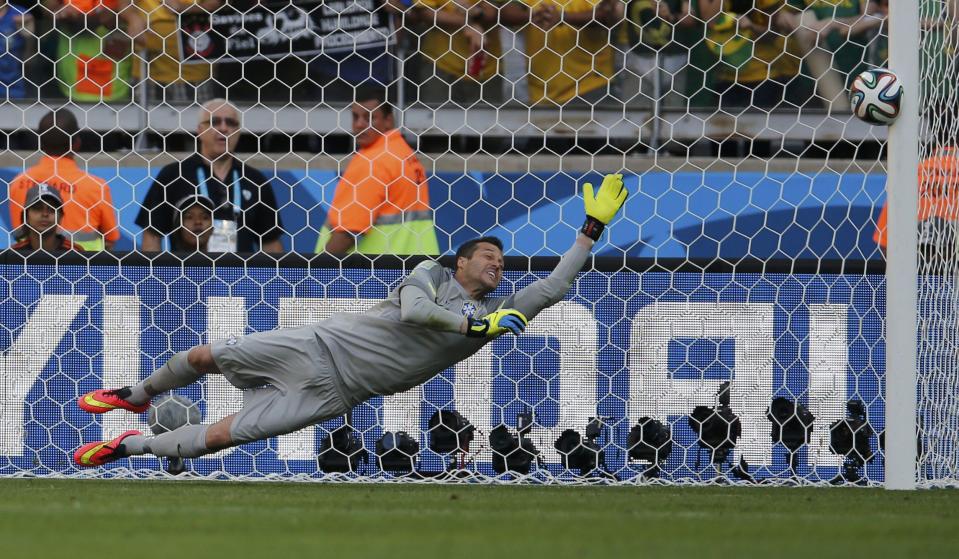 Brazil's Julio Cesar dives as the ball shot by Chile's Gonzalo Jara (unseen) rebounds off the post to decide their penalty shootout in their 2014 World Cup round of 16 game at the Mineirao stadium in Belo Horizonte June 28, 2014. REUTERS/Sergio Perez (BRAZIL - Tags: SOCCER SPORT WORLD CUP TPX IMAGES OF THE DAY)