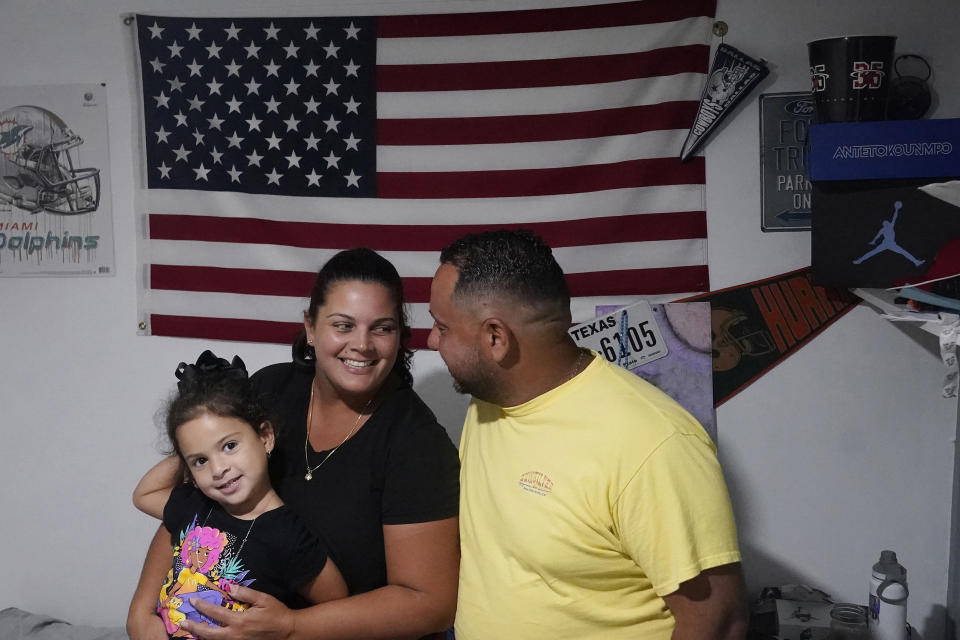 Victor Macedo, his wife Ana Merino and their daughter Sonia, sit in their son's bedroom, Wednesday, Sept. 27, 2023, in Davie, Fla. The family left everything they had and fled Venezuela and then Spain, after receiving death threats for openly opposing the socialist government of the South American country. They arrived in the U.S., almost two years ago, looking for peace and a better quality of life for their two children. (AP Photo/Marta Lavandier)