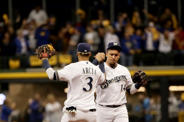 Orlando Arcia (L) and Hernan Perez of the Milwaukee Brewers celebrate after defeating the Los Angeles Dodgers in Game Six of the National League Championship Series