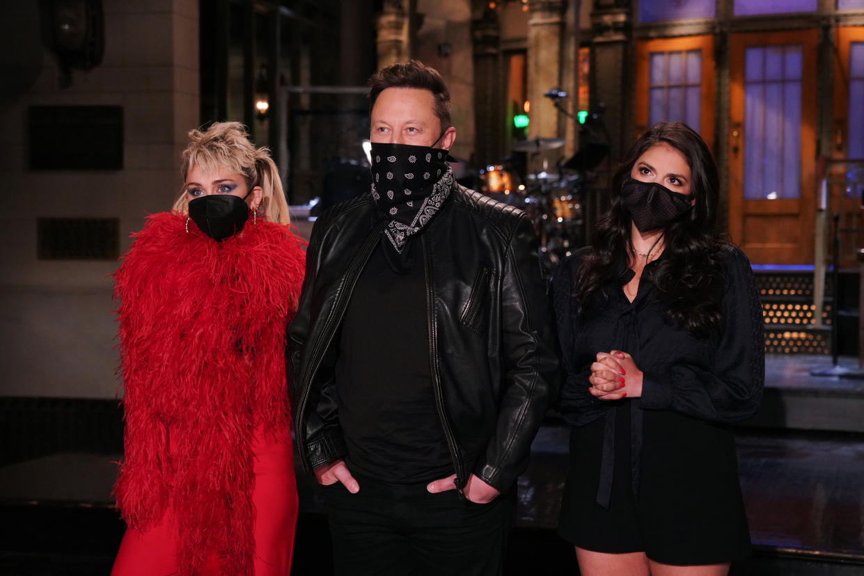 (L-R): Miley Cyrus, Elon Musk, and Cecily Strong depicted in a promo for Saturday Night Live. (Photo:  Rosalind O'Connor/NBC/NBCU Photo Bank via Getty Images)