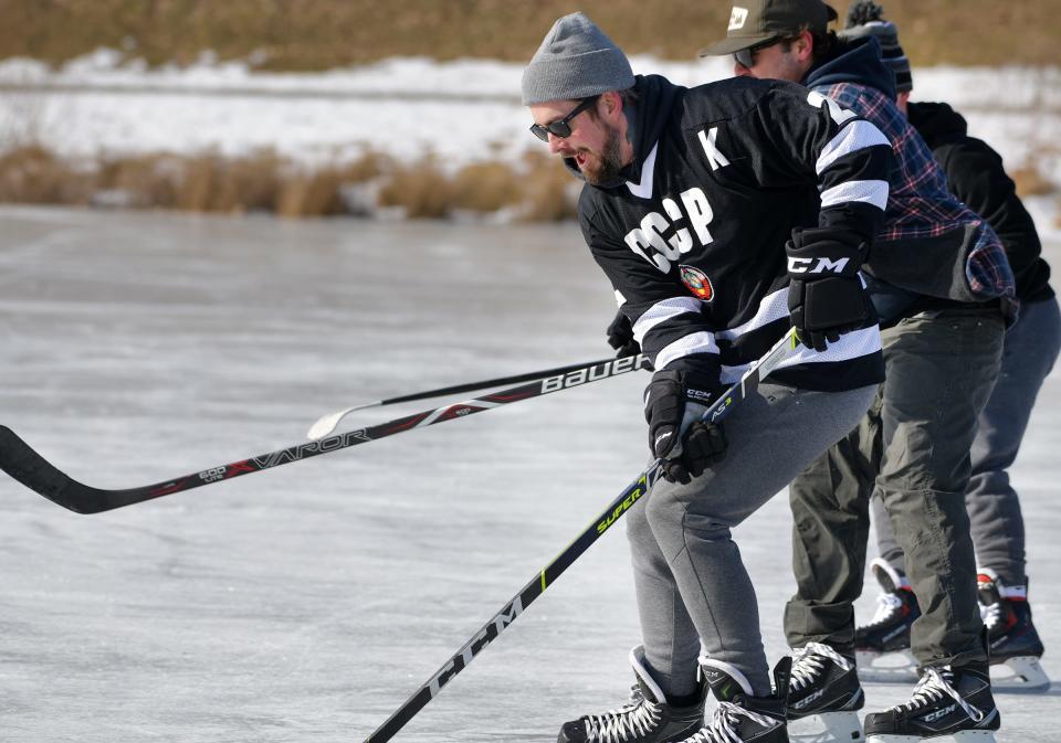 Mike Russell and others enjoy pond hockey at Elm Park Sunday.