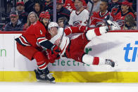Carolina Hurricanes' Jalen Chatfield (5) takes Detroit Red Wings' Lucas Raymond (23) off the puck during the first period of an NHL hockey game in Raleigh, N.C., Thursday, March 28, 2024. (AP Photo/Karl B DeBlaker)