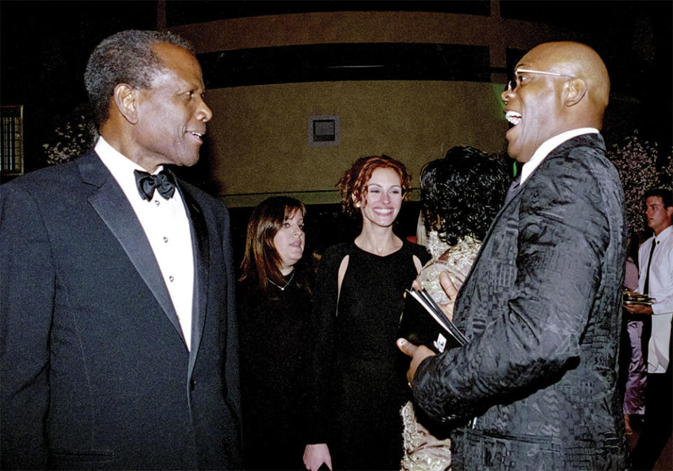 Samuel L. Jackson right congratulated Sidney Poitier, who received an honorary Academy Award at the 2002 Oscar ceremony, as Julia Roberts mingled nearby.