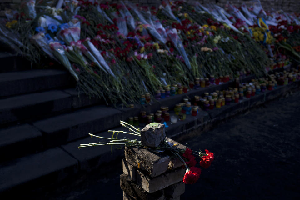 Flowers placed on paving stones in memory of those who died in clashes which took place in late February are lit by the morning sun in Kiev's Independence Square, Ukraine, Saturday, March 8, 2014. (AP Photo/David Azia)