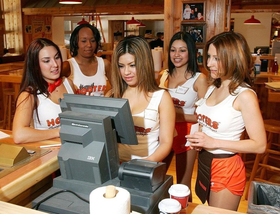 Waitresses gather around a cashier