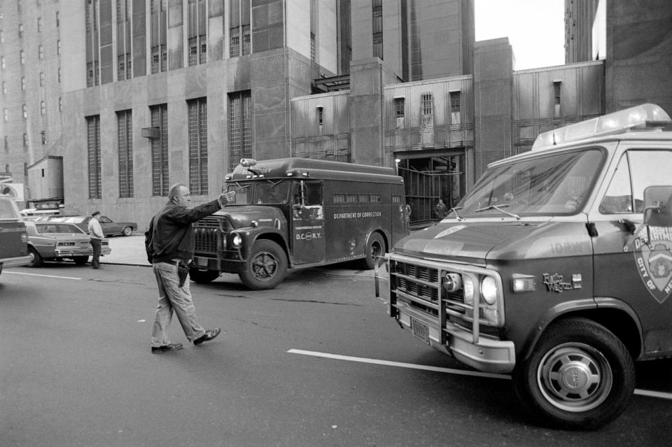 PHOTO: In this Dec. 11, 1980, file photo, a police officer holds traffic outside the Manhattan District Court as a police van carrying Mark David Chapman returns him to Bellevue Hospital, in New York. (Bettmann Archive via Getty Images, FILE)
