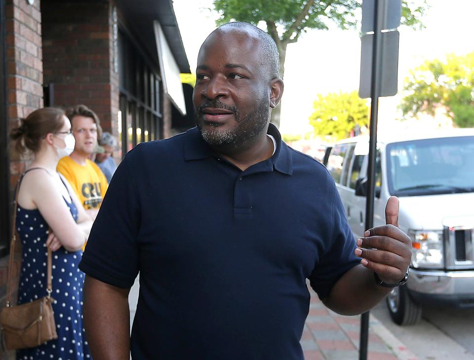 Reggie Moore, director of violence prevention for the City of Milwaukee Health Department, walks Thursday with protestors to monitor the situation on North Avenue. The protesters were demonstrating against racial injustice and in response to George Floyd ,who died at the hands of a Minneapolis police officer.