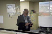 Interim Nye County Clerk Mark Kampf works on his phone in an office where early votes are being counted Wednesday, Oct. 26, 2022, in Pahrump, Nev. Ballot counting began in the county where officials citing concerns about voting machine conspiracy theories pressed forward with an unprecedented hand tally of votes cast by mail in advance of Election Day. (AP Photo/John Locher)