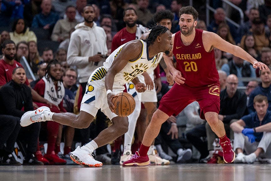 Indiana Pacers forward Aaron Nesmith (23) moves the ball around the top-of-the-key while being defended by Cleveland Cavaliers forward Georges Niang (20) during the second half of an NBA basketball game in Indianapolis, Monday, March 18, 2024.