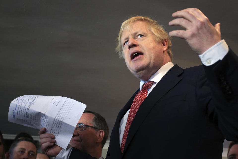 Britain's Prime Minister Boris Johnson gestures as he speaks to supporters during a visit to meet newly elected Conservative party lawmakers at Sedgefield Cricket Club in County Durham, north east England on Saturday Dec. 14, 2019, following his Conservative party's general election victory. Johnson called on Britons to put years of bitter divisions over the country's EU membership behind them as he vowed to use his resounding election victory to finally deliver Brexit. (Lindsey Parnaby / Pool via AP)