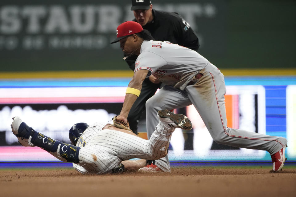 Milwaukee Brewers' Hunter Renfroe, left, slides in safely at second base past a tag by Cincinnati Reds' Jose Barrero, right, during the eighth inning of a baseball game Saturday, Sept. 10, 2022, in Milwaukee. (AP Photo/Aaron Gash)