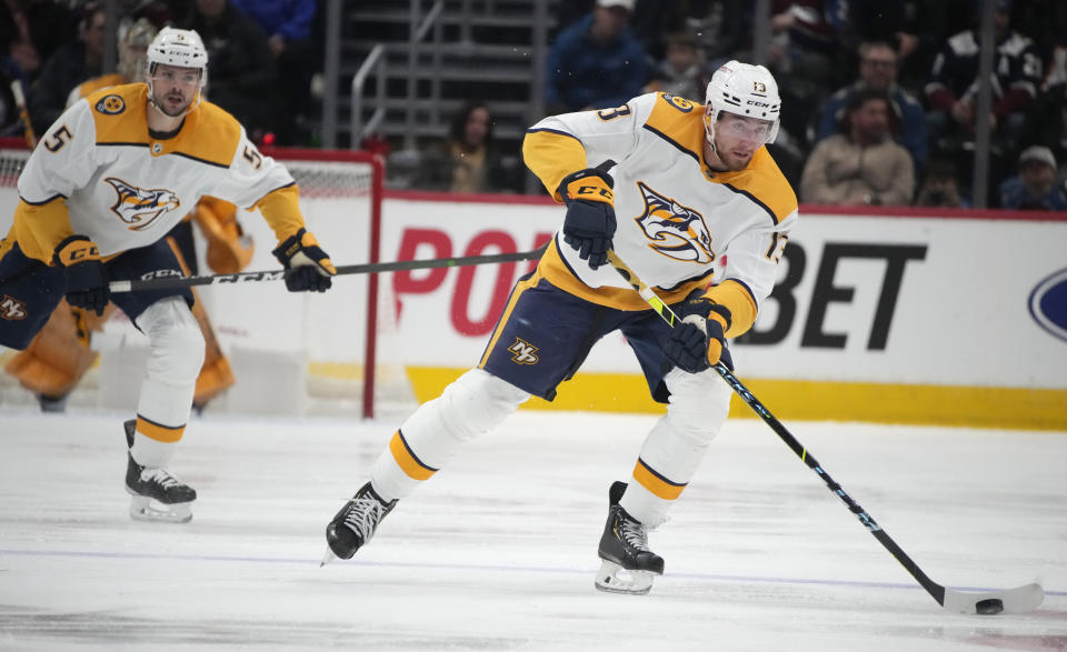 Nashville Predators center Yakov Trenin, right, looks to pass the puck as defenseman Kevin Gravel trails the play in the second period of an NHL hockey game against the Colorado Avalanche, Saturday, Dec. 17, 2022, in Denver. (AP Photo/David Zalubowski)