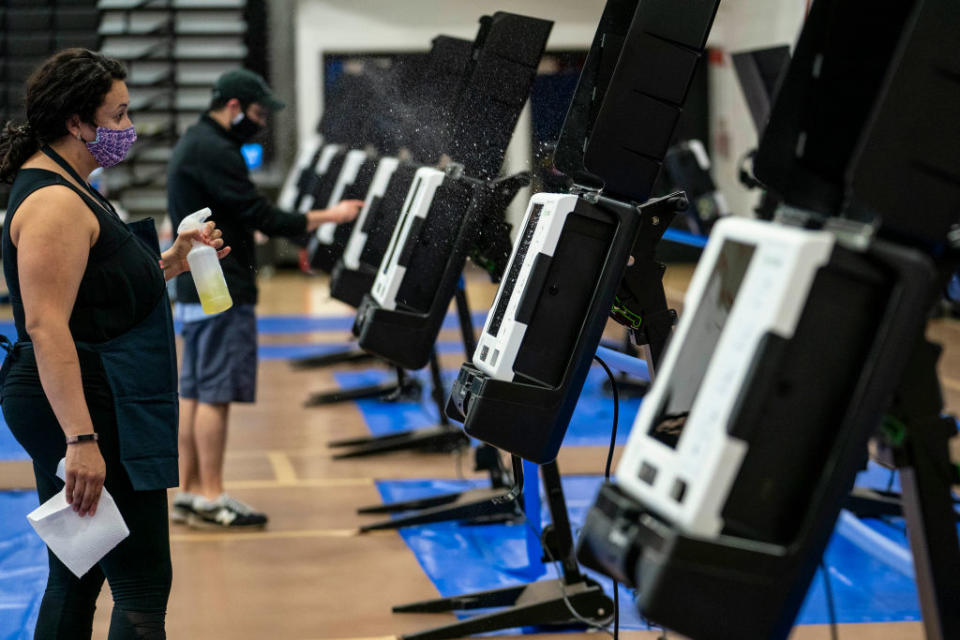 A volunteer disinfects a voting machine at an early voting centre in Washington, DC. Source: Getty