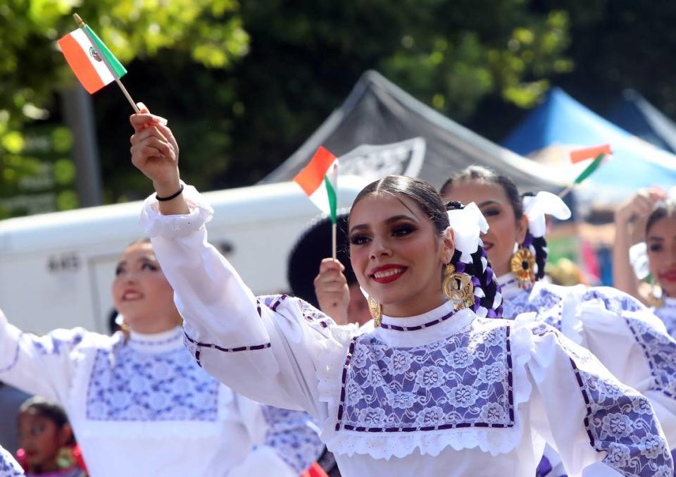 Una bailarina de la Teocalli Cultural Academy ondea la bandera mexicana durante la celebración de las Fiestas Patrias en el centro de Fresno, el 24 de septiembre de 2023.