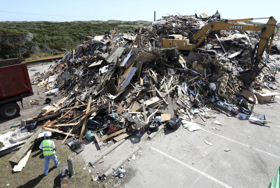 A mountain of 11,000 cubic yards of construction debris is piled in a parking lot as Ocracoke recovers from Hurricane Dorian flooding on Monday, Sept. 23, 2019. A secluded tourist destination on North Carolina’s Outer Banks is having an extremely tough year. Ocracoke Island is recovering from the most damaging hurricane in its recorded history and the near-economic paralysis wrought by one of the world’s worst pandemics. (Steve Earley/The Virginian-Pilot via AP)