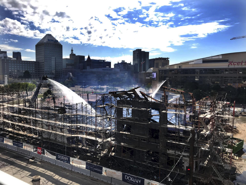 Firefighters monitor the site of an overnight fire in downtown St. Paul, Minn. on Tuesday, Aug. 4, 2020. A hotel under construction went up in flames on Tuesday morning, causing it to collapse. (Scott Takushi/Pioneer Press via AP)