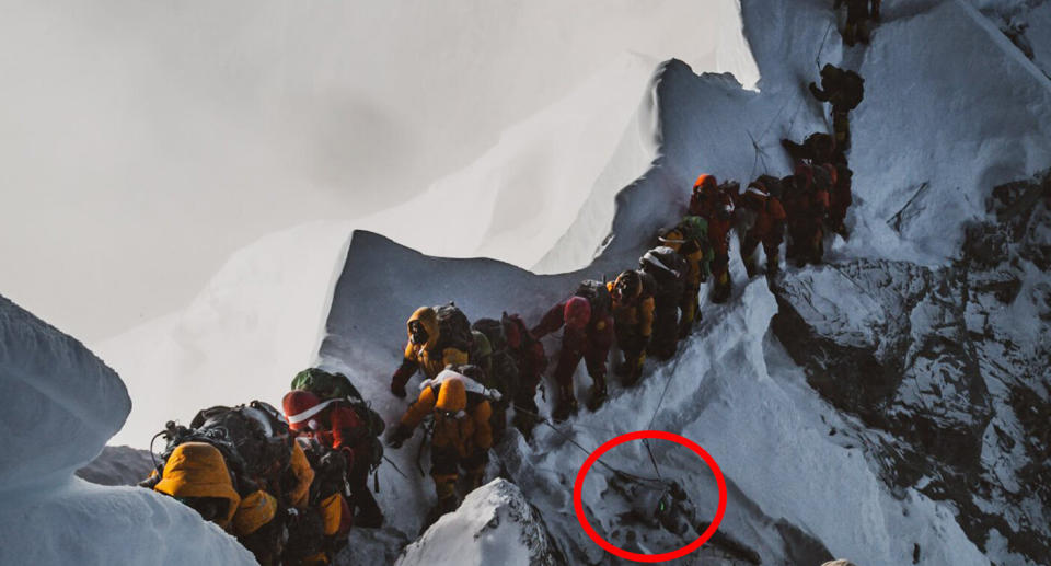 A line of climbers on Mount Everest's Hillary Step walk past a dead body. Source: Facebook/Ella Saikaly