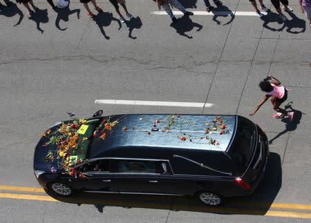 Jun 10, 2016; Louisville, KY, USA; A girl rushes to touch the hearse carrying the body of boxing legend Muhammad Ali as the funeral procession winds through his hometown of Louisville. Mandatory Credit: David Harrison/The Courier-Journal via USA TODAY NETWORK