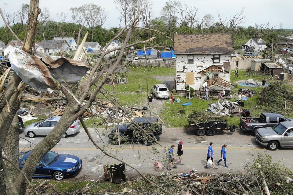 Residents walk through a tornado-damaged neighborhood on May 29, 2019 in Dayton as cleanup efforts began. A total of 21 tornadoes touched down in Ohio between May 27 and May 28, 2019.